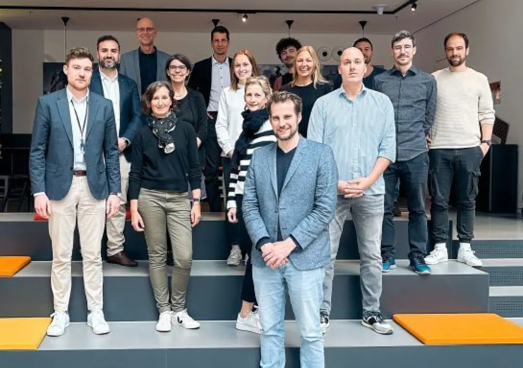 Team members standing together for a group photo in a modern office space