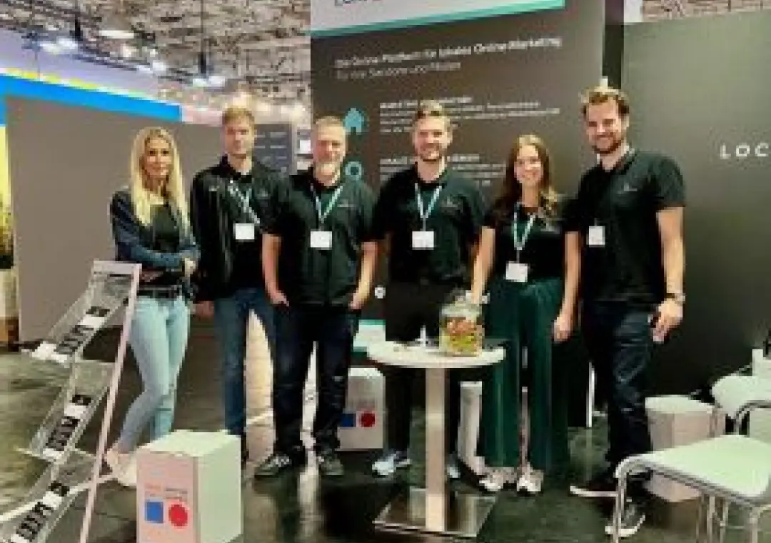 Six team members in dark clothing standing at a corporate exhibition booth