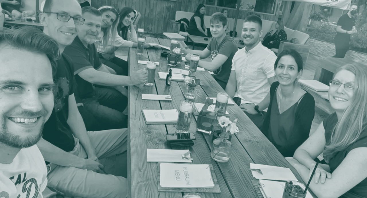 Localyzer team smiling around a long outdoor table with drinks and menus.